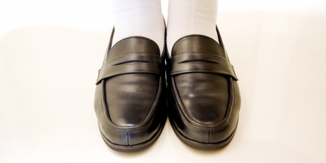 黒のローファーを履いた学生の足元のアップ